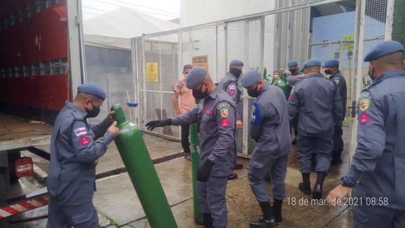 Alunos soldados da Polícia Militar do Amazonas dão apoio no transporte de cilindros de oxigênio para envio a outro estado